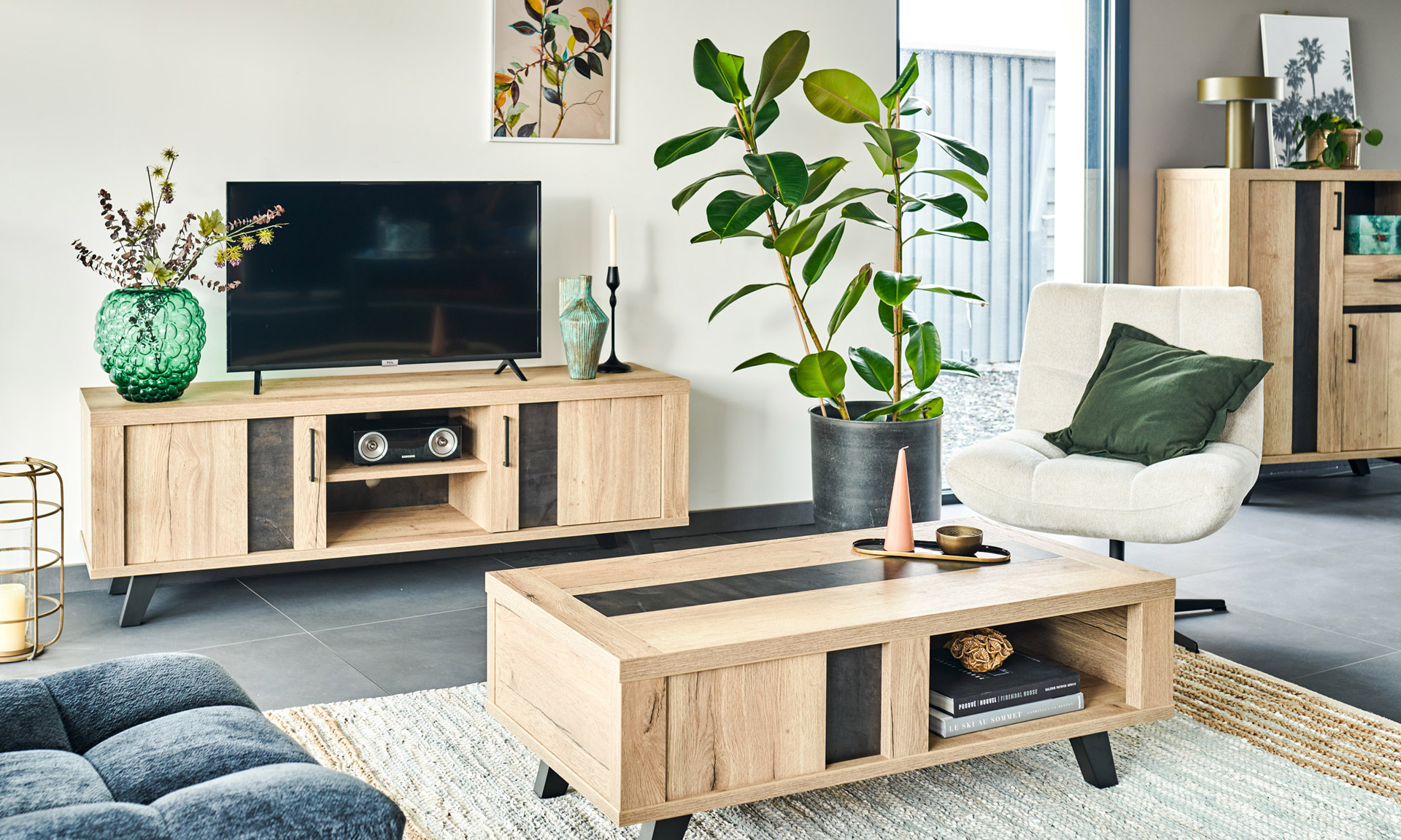 Photo d'un salon avec une collection comprenant un meuble tv, un bibus et une table basse. Les meubles présentent des finitions en chêne naturel style brut industriel et des piétements en métal noir.