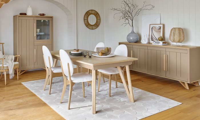 Photo présentant un salon avec une table, un bahut, une vitrine et des chaises. Chaque meuble à une finition en chêne massif blond et une peinture couleur chanvre.