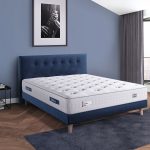 Un matelas avec Ressorts Ensachés avec un sommier et tête de lit en bleu velours.